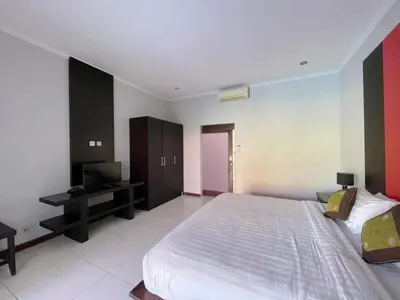 a bedroom with a large bed and a television at The Lavana Bali Radiance Arjuna Villa Seminyak in Seminyak