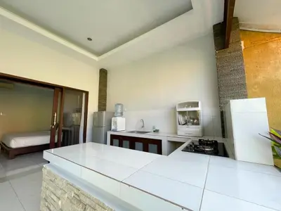 a kitchen with a white counter top and a refrigerator at The Lavana Bali Radiance Arjuna Villa Seminyak in Seminyak