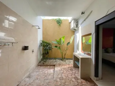 a bathroom with a sink and a shower with plants at The Lavana Bali Radiance Arjuna Villa Seminyak in Seminyak