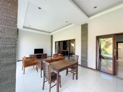 a dining room with a wooden table and chairs at The Lavana Bali Radiance Arjuna Villa Seminyak in Seminyak