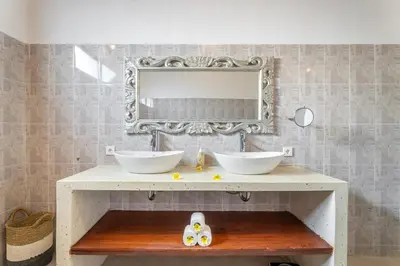 a bathroom with two sinks and a mirror on the wall at villa mangga 2 chambres seminiak in Seminyak
