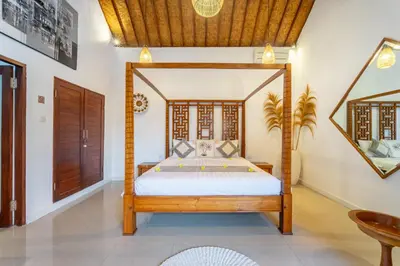 a bedroom with a canopy bed in a room at villa mangga 2 chambres seminiak in Seminyak