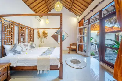 a bedroom with a bed and a large window at villa mangga 2 chambres seminiak in Seminyak