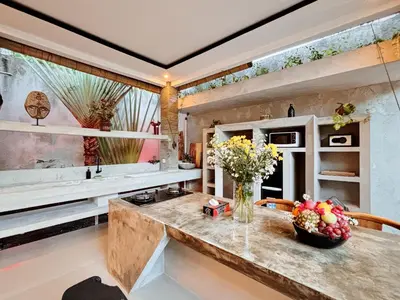 a kitchen with a counter with a vase of flowers on it at Modern 2 BR villa seminyak center. in Seminyak