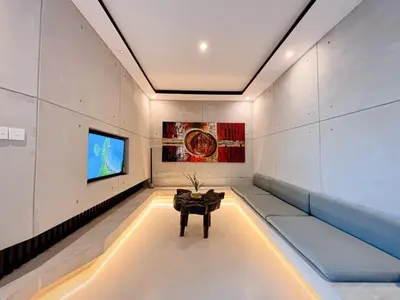 a room with a couch and a tv on a wall at Modern 2 BR villa seminyak center. in Seminyak