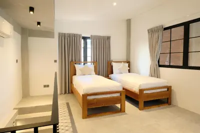 a bedroom with two beds and a window at Manresa Villa Bali 1 in Canggu