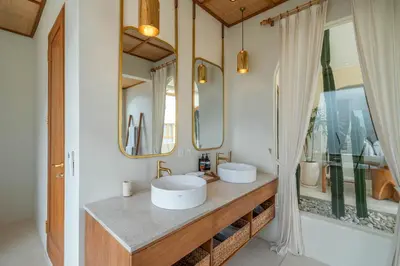 a bathroom with two sinks and two mirrors at Alegria de la Vida in Canggu