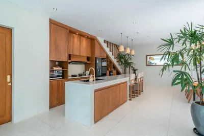 a kitchen with wooden cabinets and a kitchen island at Alegria de la Vida in Canggu