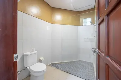 a bathroom with a toilet and a shower at De Gani in Seminyak
