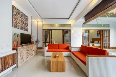 a living room with orange furniture and a tv at De Gani in Seminyak