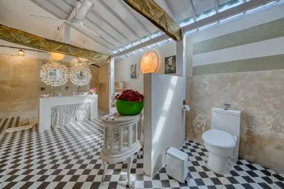 a bathroom with a white toilet and a fireplace at Villa Kalis, 10 BR family and group Villa in Seminyak