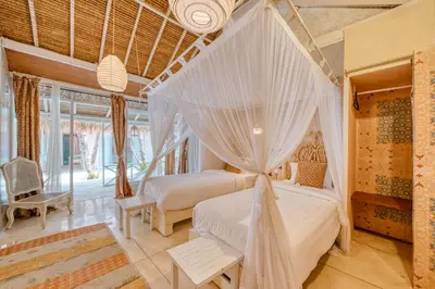 a bedroom with two beds with mosquito nets at Villa Kalis, 10 BR family and group Villa in Seminyak