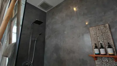 a bathroom with a shower and a shelf with wine bottles at Villa Sanya Berawa in Canggu
