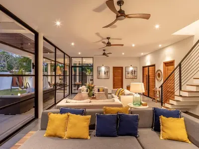 an open living room with a couch and a ceiling fan at Villa Sanya Berawa in Canggu