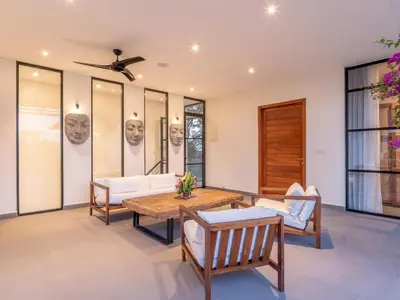 a living room with a table and chairs at Villa Sanya Berawa in Canggu