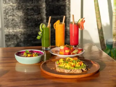 a table with two plates of food and two drinks at Villa Sanya Berawa in Canggu