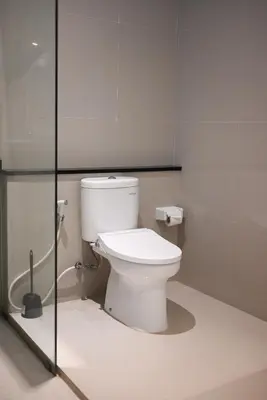 a bathroom with a toilet and a glass shower stall at Villa Laksmi Legian in Seminyak