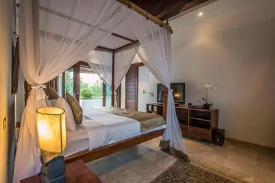 a bedroom with a canopy bed with a window at Beautiful & Luxurious 3-Bedroom Private Villa With Pool 150-Metres To Seminyak Beach in Seminyak