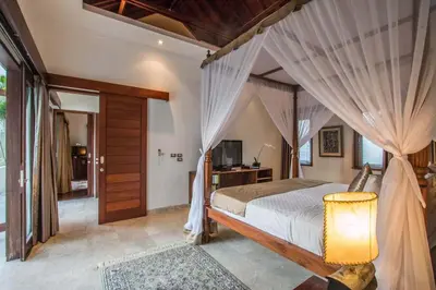 a bedroom with a canopy bed and a television at Beautiful & Luxurious 3-Bedroom Private Villa With Pool 150-Metres To Seminyak Beach in Seminyak