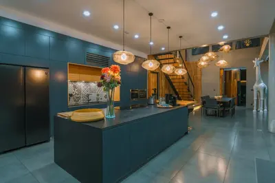 a kitchen with blue cabinets and a counter with flowers on it at Villa Aless - Designer 4BR Villa with Sauna, Jacuzzi, Ice Bath, Gym & Rooftop in Canggu