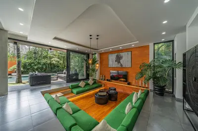 a living room with green couches and a table at Villa Aless - Designer 4BR Villa with Sauna, Jacuzzi, Ice Bath, Gym & Rooftop in Canggu