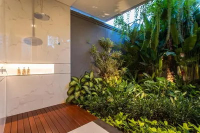 a bathroom with a large indoor plant at The Amarta Villa in Jimbaran