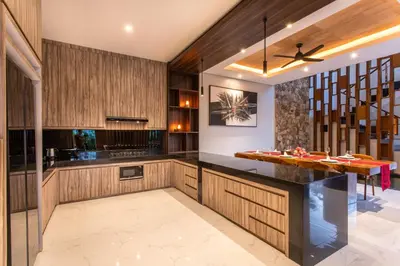 a kitchen with wooden cabinets and a large island at The Amarta Villa in Jimbaran