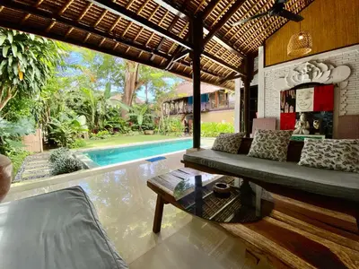 a living room with a couch and a pool at Little Tree House in Sanur