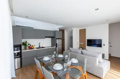 a kitchen and a living room with a table and chairs at 20 Suites Umalas in Canggu