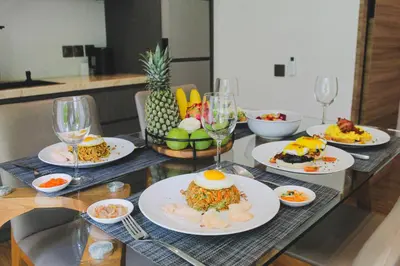 a table with plates of food and glasses of wine at 20 Suites Umalas in Canggu