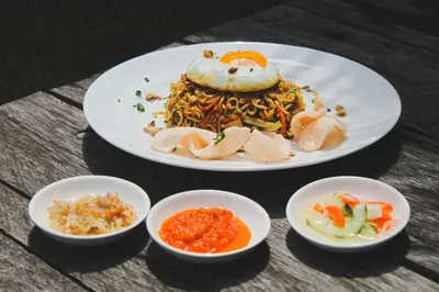 a plate of food on a table with bowls of food at 20 Suites Umalas in Canggu