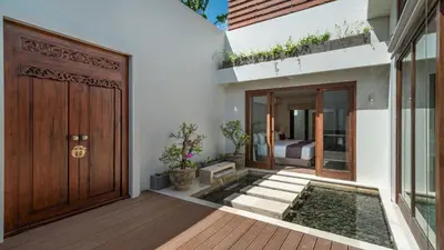 a house with a wooden door and a bedroom at Villa Emmy by Elite Havens in Seminyak