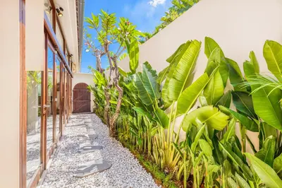 a walkway in front of a building with plants at NEW Fresh 3BD Prime Location Villa in Seminyak
