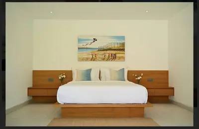a bedroom with a bed and a painting on the wall at Tatkala Villa Seminyak in Seminyak