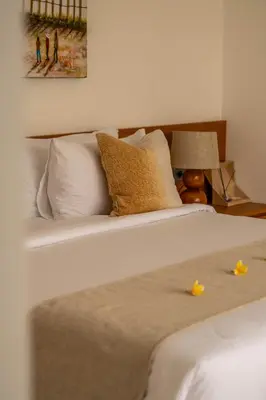 a white bed with two yellow flowers on it at Tatkala Villa Seminyak in Seminyak