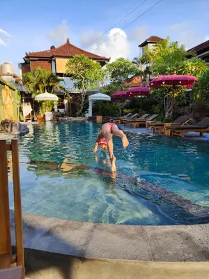 a person in the water at a swimming pool at Berlian Inn Kuta Beach in Kuta