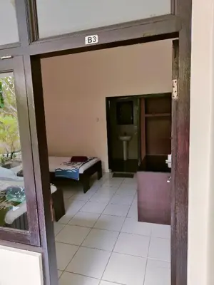 a view of a room with a bed and a bathroom at Berlian Inn Kuta Beach in Kuta
