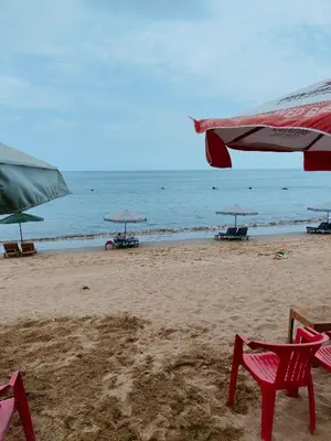 a group of chairs and umbrellas on a beach at Berlian Inn Kuta Beach in Kuta