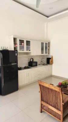 a kitchen with a black refrigerator and a table at Villa Keane Bali 2 BR, Private Pool in Seminyak