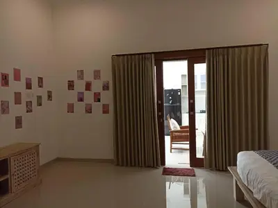 a bedroom with a bed and a sliding glass door at Villa Keane Bali 2 BR, Private Pool in Seminyak
