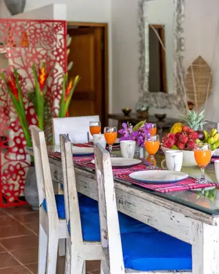 a table with chairs and a table with fruit on it at Villa Fendi Seminyak in Seminyak
