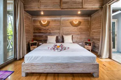a bedroom with a large bed with wooden walls at Villa Fendi Seminyak in Seminyak