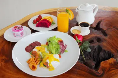 a table with a plate of breakfast food and orange juice at Agata Villas Seminyak in Seminyak