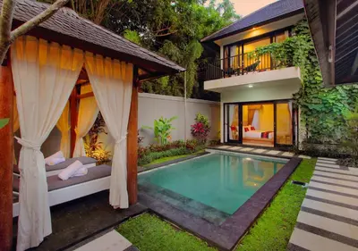 a villa with a swimming pool and a house at Agata Villas Seminyak in Seminyak