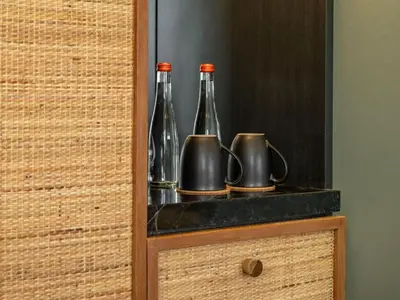 a cabinet with two bottles and pitchers on a shelf at The Isvara by Cove in Seminyak