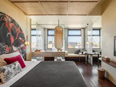 a bedroom with a bed and a bathroom with a sink at The Isvara by Cove in Seminyak