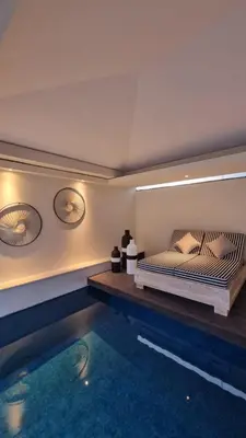 a bedroom with a bed and a swimming pool at VILLA CELAVI 15 in Kerobokan