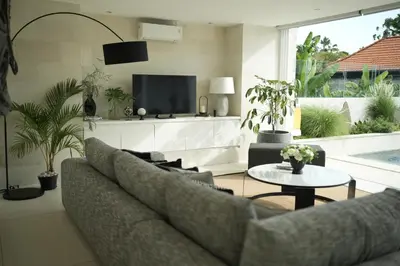 a living room with a couch and a tv at VILLA CELAVI 15 in Kerobokan