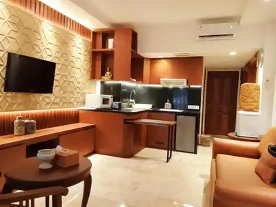 a living room with a kitchen with a counter top at The Palmana Courtyard Jayakarta Residence 2 in Seminyak