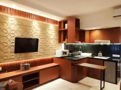 a kitchen with a counter and a tv on the wall at The Palmana Courtyard Jayakarta Residence 2 in Seminyak